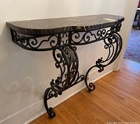 Front left angle showing curved marble top and metal scrollwork base