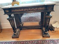 Front view of carved wood console table with marble top and mirror