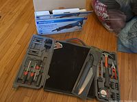 Lot arranged on floor showing Mastercraft reciprocating saw box, Yardworks pruning saw in package, and open plastic tool case with various tools.