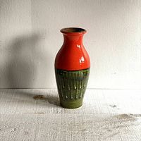 Front view of vintage Austrian pottery vase showing red-orange upper glaze and olive green lower glaze with drip texture.