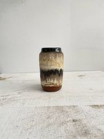 Front view of a cylindrical vintage West Germany pottery vase with a brown drip glaze design on a neutral background.