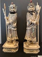Two carved Japanese warrior figurines front view on bases