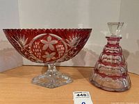Photo of the red cut glass pedestal bowl and decanter side by side on shelf