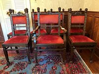 Seven carved oak chairs grouped, showing overall set