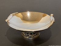 Front three-quarter view showing overall dish shape, reflective finish, bead accents, and openwork foot