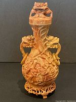 Full view of urn on stand showing lid, body carvings and base