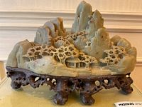 Front view of entire jade carving on wooden stand