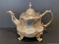 Frontal view showing overall shape, body, spout, handle, and three claw feet