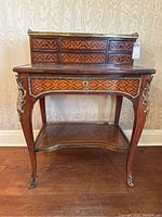 Full frontal view showing five small upper drawers, single lower drawer, open shelf and brass gallery rail top