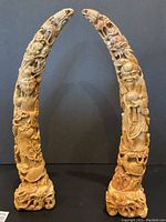 Front view of both horn-shaped sculptures side by side against black background