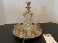 Full lot on tray: decanter centered, six glasses around, on round tray