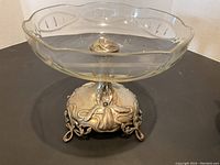 Full view of clear glass bowl seated on sterling silver Art Nouveau style base