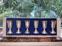 Overview of six Kiddush cups in original box with blue velvet lining