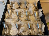 All twelve sterling silver cordial holders with glass liners arranged in original case packed in tissue.