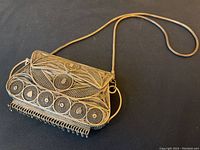 Angled front view showing filigree pattern and chain strap