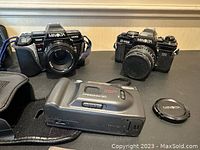 Overview of two Minolta SLRs and one Freedom 50 point-and-shoot, plus case and lens cap
