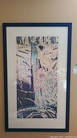 Framed abstract artist proof print hanging on wall, full view