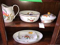 Five-piece Evesham set displayed on shelf: pitcher, serving bowl, covered dish, rectangular dish on oval platter