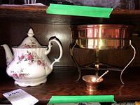 Overall view of Royal Albert teapot, copper pot on stand, and mini copper mortar and pestle together on shelf