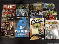 Full lot shot showing 12 trade paperback and hardcover graphic novels.