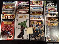 Photo showing all 20 high grade comics carefully bagged and boarded. Titles from DC and Marvel universes visible, with several Batman, Justice League, Green Arrow, and X-Men related comics.