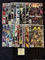 Front view of 20 bagged and boarded DC comic books laid out in two rows on a dark surface