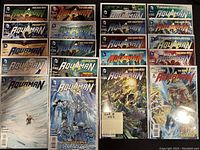 Photo showing 20 high grade Aquaman comics, all bagged and boarded, arranged in a grid. The comics feature various covers with Aquaman and other DC characters, including crossover issues.