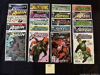 Photo showing 20 high grade comics including Robin, Nightwing, and multiple Green Lantern issues neatly arranged in rows, all bagged and boarded.