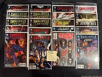 Photo showing 20 high grade comics including Smallville, Superman, X-Men, Batman, Jonah Hex, Heroes for Hire, Bane titles, all bagged and boarded.