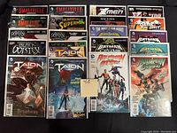 Photo of 20 high grade comic books featuring various popular superhero series. Comics are arranged in 4 rows, bagged and boarded. Visible titles include Smallville, X-Men, Guardians of the Galaxy, Talon, Superman, Robin, Aquaman, Batgirl, X-Factor.