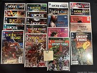 Photo of 20 comic books bagged and boarded in protective sleeves. Includes titles Suicide Squad, Stephen King adaptations, Arrow, and Swamp Thing.
