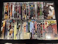 Photo showing 50 comic books in clear protective sleeves arranged in rows, a mix of mid to high-grade condition comics from various publishers.