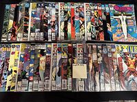 Two rows of 50 bagged and boarded comic books, showing a mix of DC and Marvel titles and a range of issue numbers and cover art.