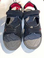 Top view of a pair of black Air Showstopper sandals showing front straps and contoured footbed with red lining.