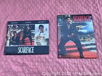 Two framed Scarface-themed pictures featuring Al Pacino, placed on a pink textile.