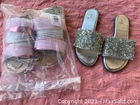 Two pairs of slippers, one silver with large sparkly stones, the other light pink and sealed in plastic