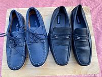Two pairs of men's formal shoes, one pair blue lace-up shoes, one pair black slip-on loafers.