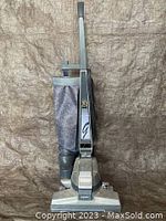 Kirby upright vacuum cleaner in grey with cloth collection bag, standing upright against a background