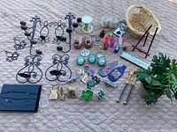 Full view of the lot showing various decorative objects including candle holders, figurines, planters, and other small decor items on a beige surface.