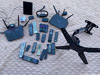 Overview showing all items: multiple remote controls, three WiFi routers, and one black TV wall mount.