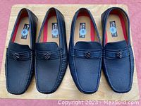 Two pairs of men's black dress shoes in size 9 displayed side by side on wood surface. Front view showing design and metal emblem detail.