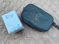 Dark-colored Disney cross-body bag with Mickey Mouse outline print and original Disney box next to it