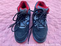 Front and top view of pair of Nike Air Flight 89 sneakers showing black suede and mesh upper, black laces, red inner lining and sole.