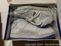 Pair of white Nike Air shoes with royal blue accents in original box, new and unused.