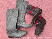 Two pairs of women's boots side by side on a pink surface, showing the full gray knee-high boots and brown embroidered ankle boots.