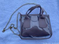 Photo of one mini clear square bag in beige with double handles and a gold chain strap