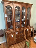 Front view of china cabinet showing glass doors filled with glassware and drawers below