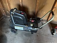 Side view of Husky air compressor showing wheels, handle, power switch, and label.