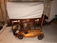 Full view of the covered wagon lamp with attached vintage wooden model car in front