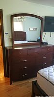Full view of dresser with mirror attached in bedroom setting